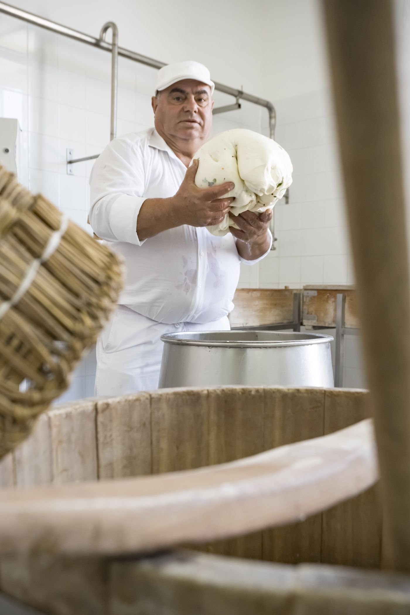 Il casaro modella la pasta filata appena estratta dalla caldaia
