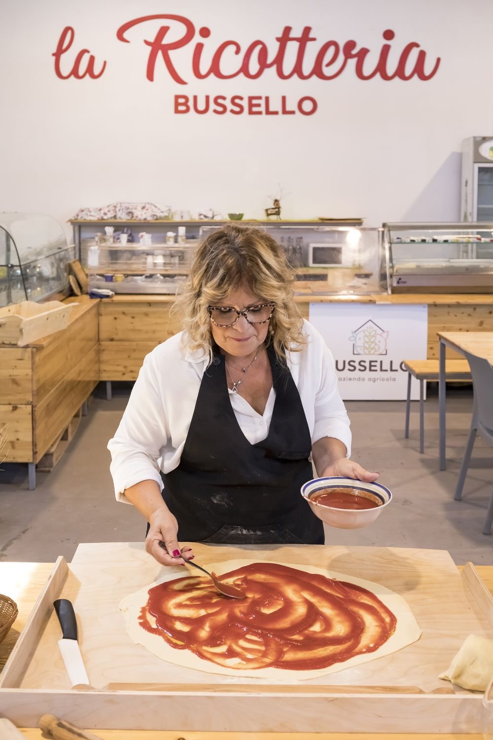 La salsa di pomodoro viene stesa a spirale sulla sfoglia